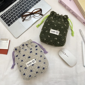 Soft fleece drawstring storage pouches in forest green and polka dot beige patterns