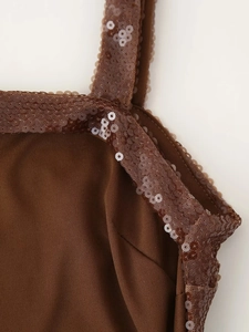 Macro shot of dark brown knit fabric featuring shimmering sequin details on the neckline