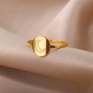 Detailed view of an 18K gold-plated stainless steel ring with an engraved moon on silk