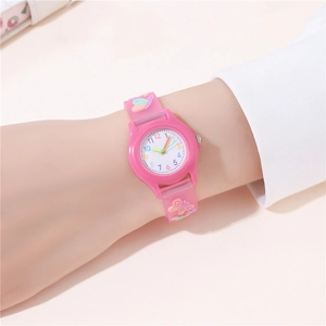 Close-up of pink children watch with embossed butterflies on wrist against light pink background