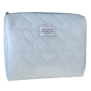 Light blue heart quilted makeup bag with zipper closure and decorative fabric label
