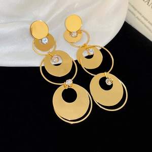 Close-up of golden multi-layer circular zircon tassel earrings on elegant silk background