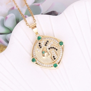 Macro detail of 18K gold rotating leopard head pendant with emerald and zircon stones