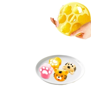 Yellow bear and cat paw silicone cake mold with homemade snacks on a white plate