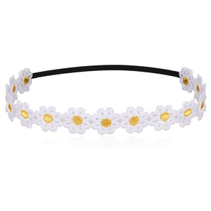 Close-up of white daisy embroidery flower on a black elastic headband for babies