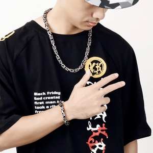 Detailed view of silver Byzantine chain necklace and bracelet set on male model