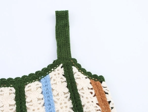 Close-up of crochet knit camisole showing floral embroidery and green shoulder straps
