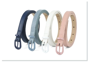 Detail view of slim leather belts in navy, light blue, white and pink with pin buckles