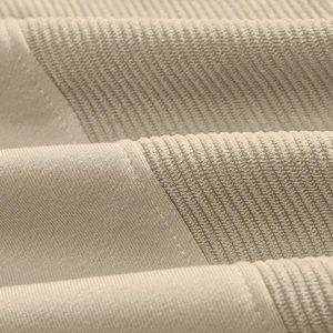 Detailed texture of beige corduroy and smooth knit fabric splicing on sweatshirt