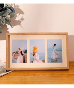 Close-up of triple wood photo frame with natural grain finish on a wooden tabletop