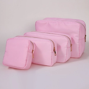 Set of four pink nylon cosmetic bags in various sizes with premium gold zippers