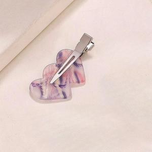 Detailed close-up of marble pattern heart-shaped acetate hair clip with metal duckbill base