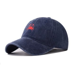 Close-up of vintage washed navy baseball cap with red crab embroidery and twill texture