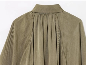 Détail de chemise en popeline vert olive montrant les coutures du col et la texture