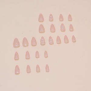 Pink almond press-on nails with white bow designs and pearls on a beige background