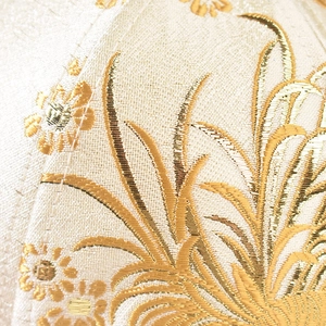 Macro detail of Chinese style floral embroidery and golden jacquard texture on cap