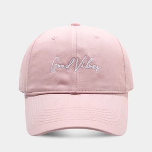 Detail of pink cotton baseball cap featuring white Good Vibes script embroidery on front