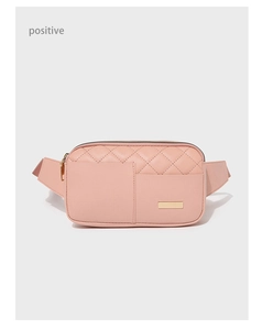 Detailed close-up of pink quilted leather waist bag with golden zipper and logo plate