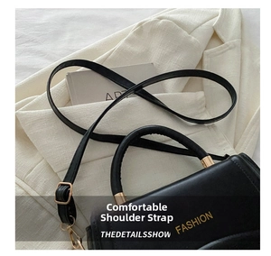 Detail of black lychee grain leather texture with gold metal buckle and adjustable strap
