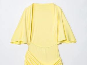 Detailed view of yellow maxi dress featuring ruffled bell sleeves and pleated waist texture