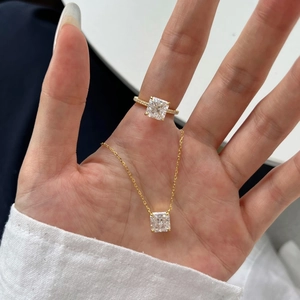 Close-up of square-cut zircon pendant necklace and matching gold-plated diamond ring
