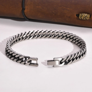 Detailed close-up of a silver stainless steel Cuban link bracelet with a fold-over clasp