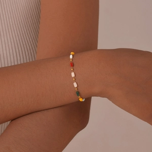 Dettaglio di perline colorate sfaccettate e distanziatori dorati su un bracciale chic