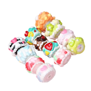 Assorted colorful resin dessert beads featuring mini donuts and cakes on white background