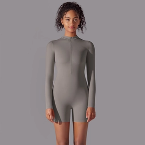Detail of gray long-sleeve athletic jumpsuit featuring half-zip neckline and bodycon fit