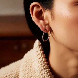 Créoles minimalistes dorées avec zircons portées par un mannequin au style élégant
