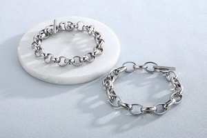 Detailed view of silver titanium steel bracelets featuring round and oval links with OT buckles