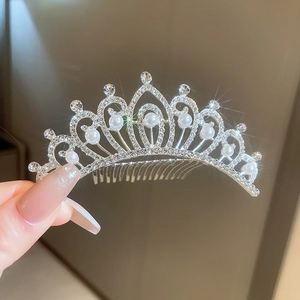 Gros plan d'un peigne à cheveux couronne argentée avec strass brillants et perles
