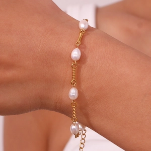 Detailed shot of baroque pearls and twisted gold metal links on a 18K plated bracelet