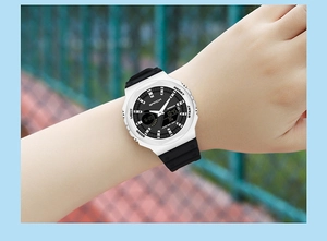 Detail of dual-display waterproof sports watch with white case and black strap on wrist