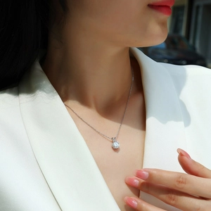 Elegant 925 silver necklace with round moissanite pendant on a model's collarbone