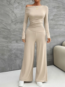 Detail of beige one-shoulder long sleeve top and wide-leg trousers set with ruched fabric