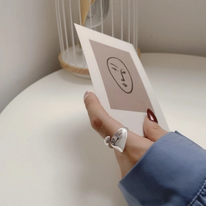 Detail showing an elegant S925 sterling silver drop open ring on a model's hand