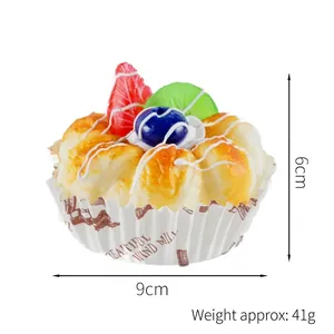 Artificial fruit cupcake model with strawberries and kiwi in a white paper liner