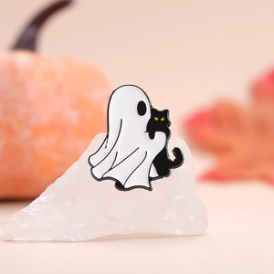 Halloween enamel pin with white ghost holding black cat on white crystal stone display