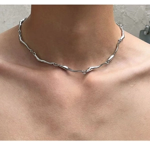 Close-up of irregular wave chain necklace in silver on model's neck for a minimalist look