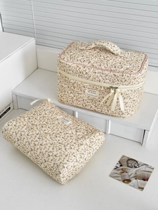 Détail de deux trousses de maquillage à fleurs en coton matelassé avec ruban et fermeture