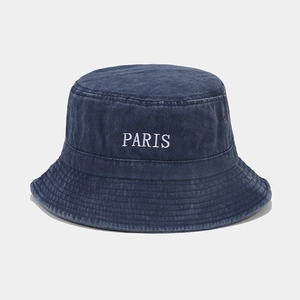 Close-up of embroidered white PARIS letters on washed navy blue cotton bucket hat
