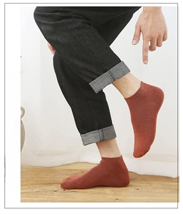 Detail of terracotta combed cotton ankle sock showing fine knit texture on male foot