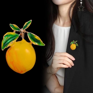Fresh lemon fruit brooch with yellow enamel and green leaves on black suit lapel