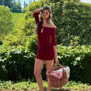 Detailed view of the dark red mini dress featuring a teardrop cutout and ruffled long sleeves