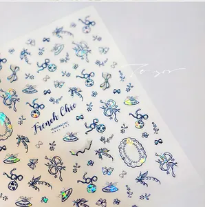 Macro detail of holographic French Chic nail stickers with floral patterns and bows
