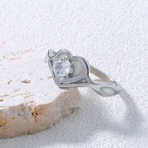 Detail of heart-shaped stainless steel ring with white enamel and center zircon stone
