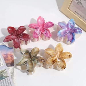 Detail of five-petal flower hair claws in gradient marble textures and assorted colors