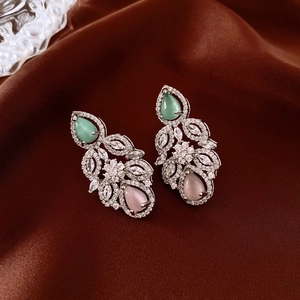 Close-up of teardrop cat-eye stone earrings with sparkling zircon leaf patterns
