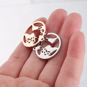 Close-up of rose gold and silver world map cut-out charms in stainless steel